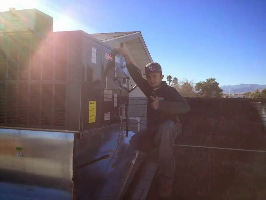 HVAC technician performing Boiler Repair on a rooftop unit in Rochester